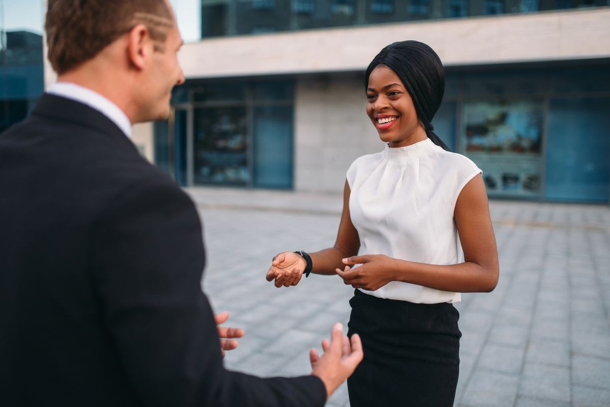 Business woman and businessman, outdoors meeting